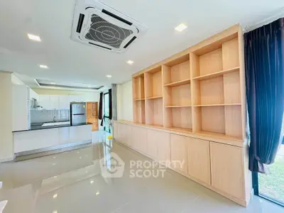 Spacious modern kitchen with open layout and built-in wooden shelving