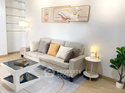 Modern living room with stylish decor, featuring a beige sofa, elegant artwork, and a chic coffee table.