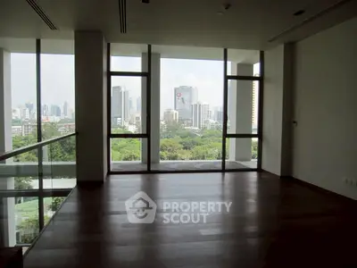 Spacious modern living room with floor-to-ceiling windows and stunning city view.