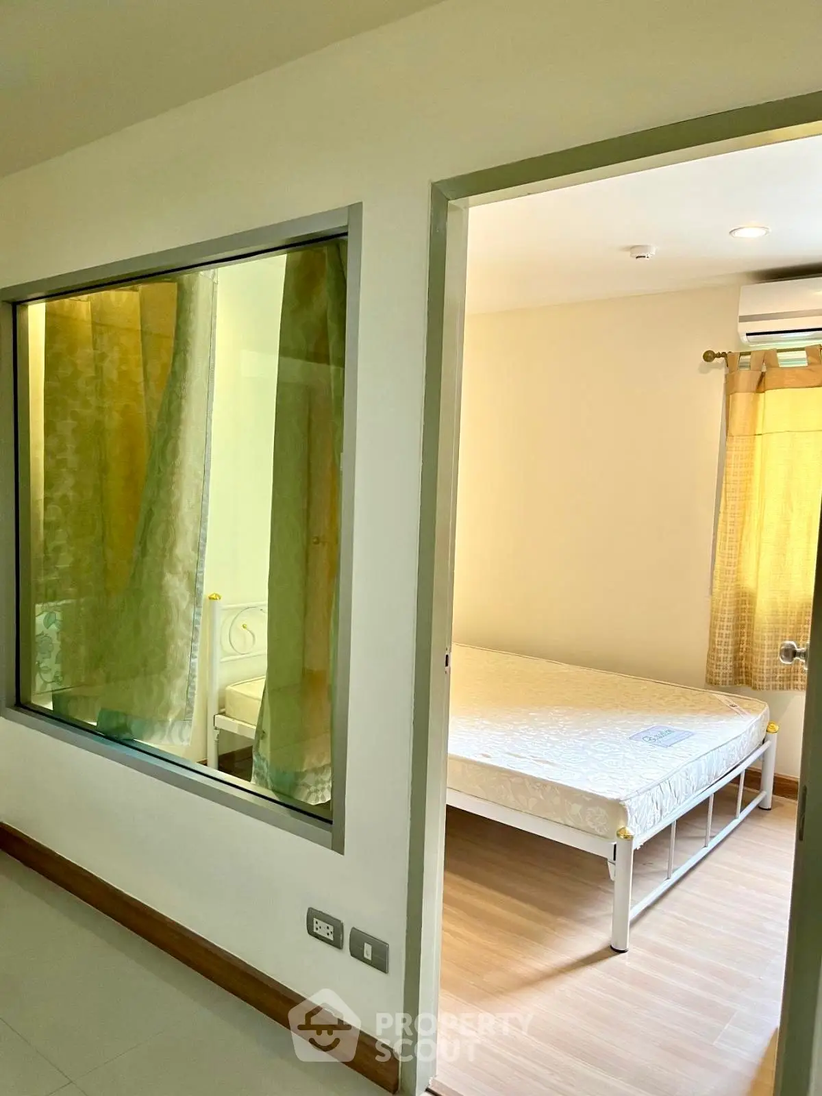 Spacious bedroom with large window and natural light, featuring a comfortable bed and modern decor.