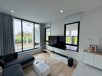 Modern living room with large windows and sleek furniture, offering a bright and inviting atmosphere.