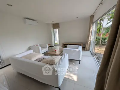 Bright and airy living room with modern white sofas and garden view.