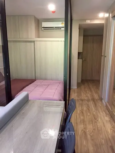 Modern compact bedroom with wood flooring and air conditioning