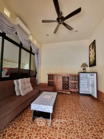 Cozy living room with stylish furniture and open fridge, featuring elegant ceiling fan and decorative curtains.