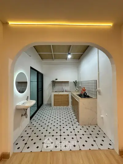Charming kitchen with open layout and modern design, featuring stylish tiles and elegant lighting.