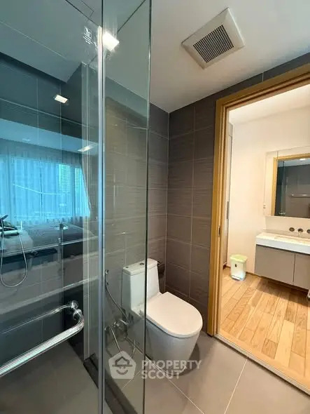Modern bathroom with glass shower and sleek fixtures in contemporary home.