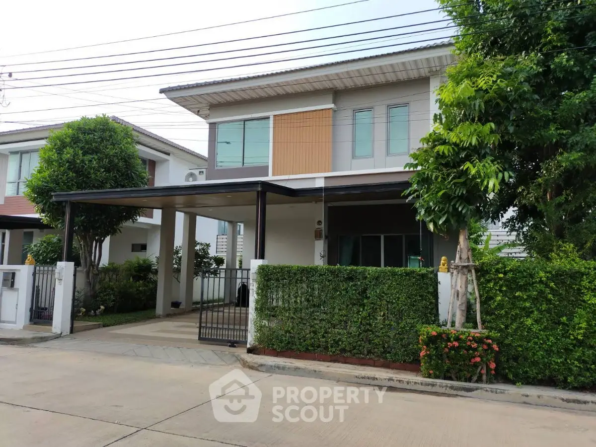 Charming two-story house with lush greenery and modern design in a serene neighborhood.