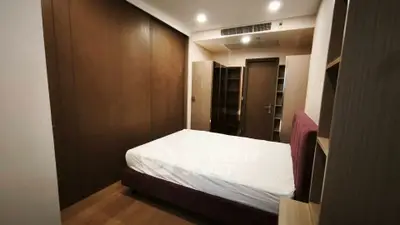 Cozy bedroom with modern wooden wardrobe and comfortable bed