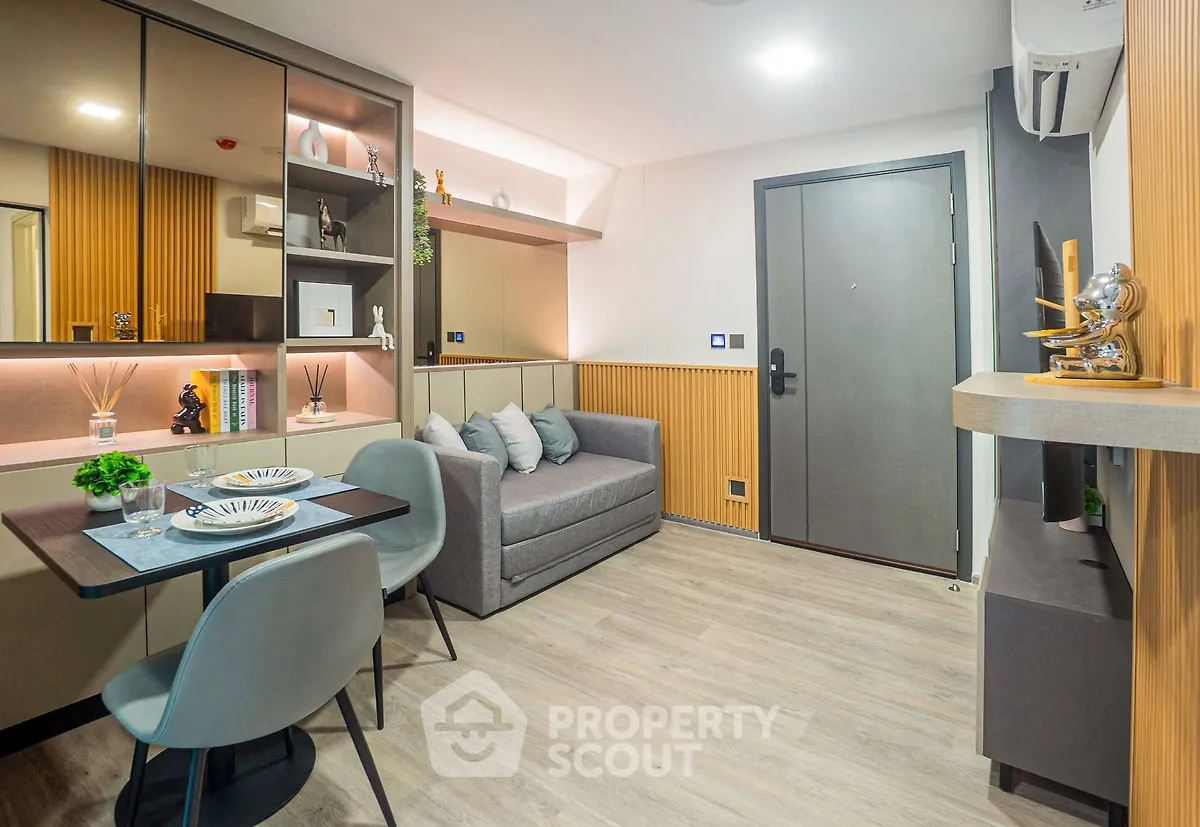 Modern living room with stylish decor and compact dining area in a cozy apartment.
