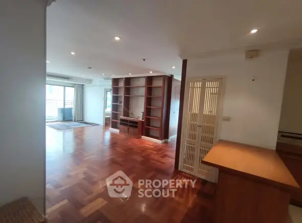 Spacious living room with wooden flooring and built-in shelving