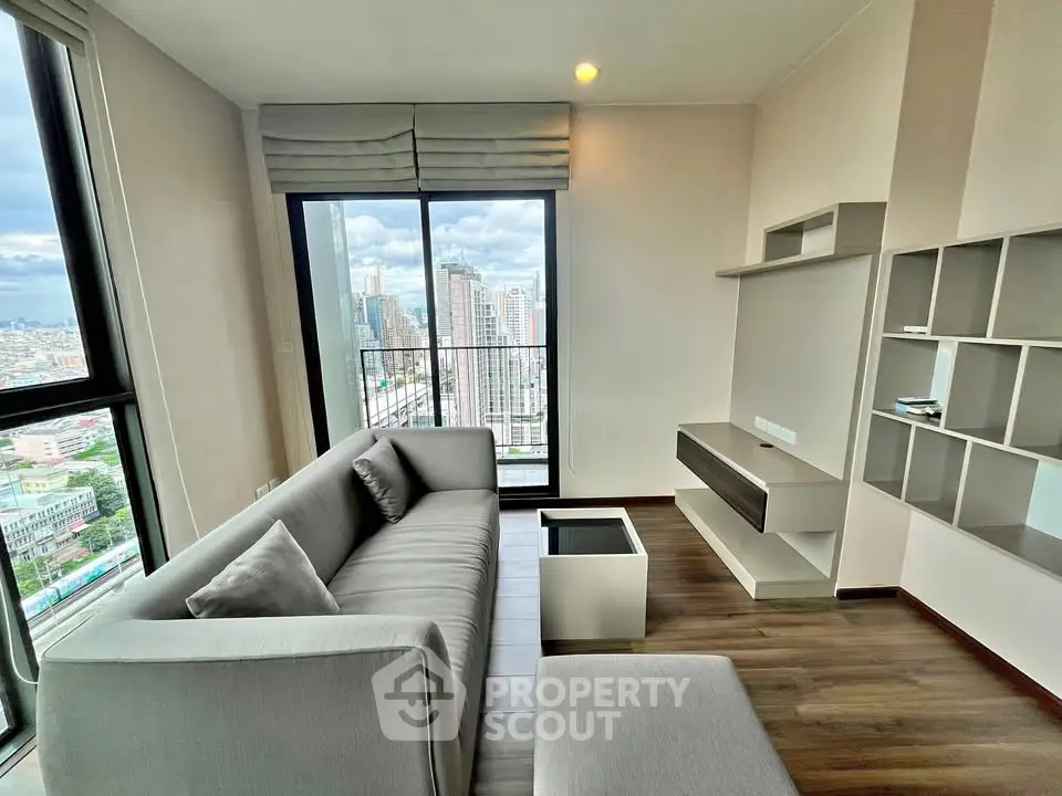 Modern living room with city view and sleek furniture in high-rise apartment.