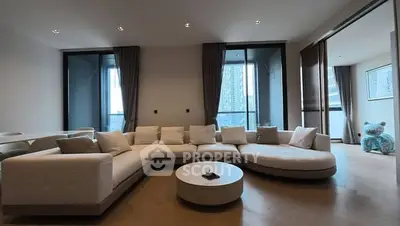 Spacious modern living room with large sectional sofa and floor-to-ceiling windows.