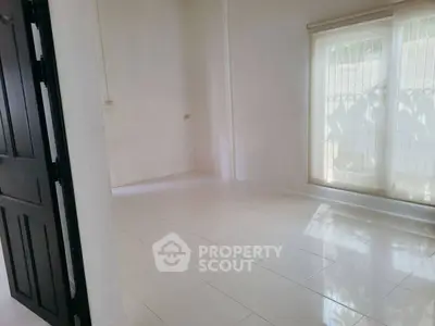 Spacious empty room with large window and tiled floor, perfect for customization.