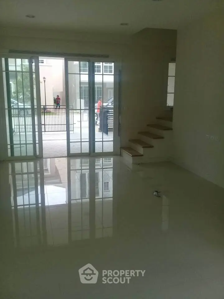 Spacious living room with glossy floors and large sliding glass doors