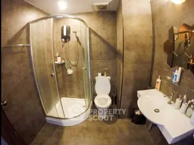 Modern bathroom with glass shower and stylish sink in a contemporary apartment.