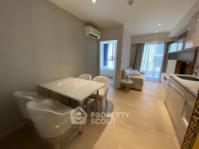 Modern open-plan living room and kitchen with sleek furniture and natural light