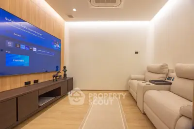 Luxurious home theater room with plush seating and large flat-screen TV, perfect for entertainment.