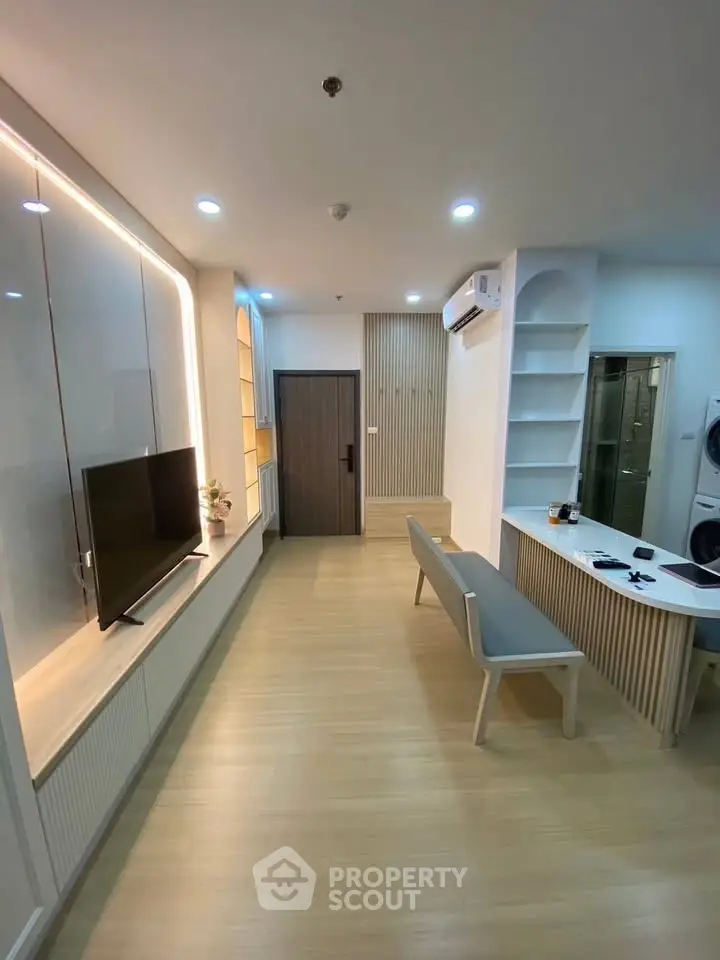 Modern living room with sleek design, featuring built-in TV unit and stylish bench seating.