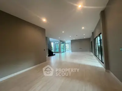 Spacious modern living room with large windows and elegant lighting