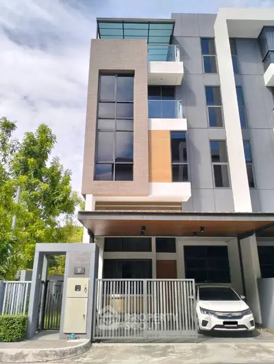 Modern multi-story townhouse with sleek design and gated entrance