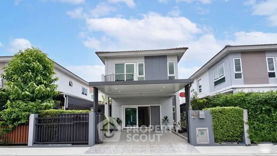 Modern two-story house with spacious driveway and lush greenery in a serene neighborhood.