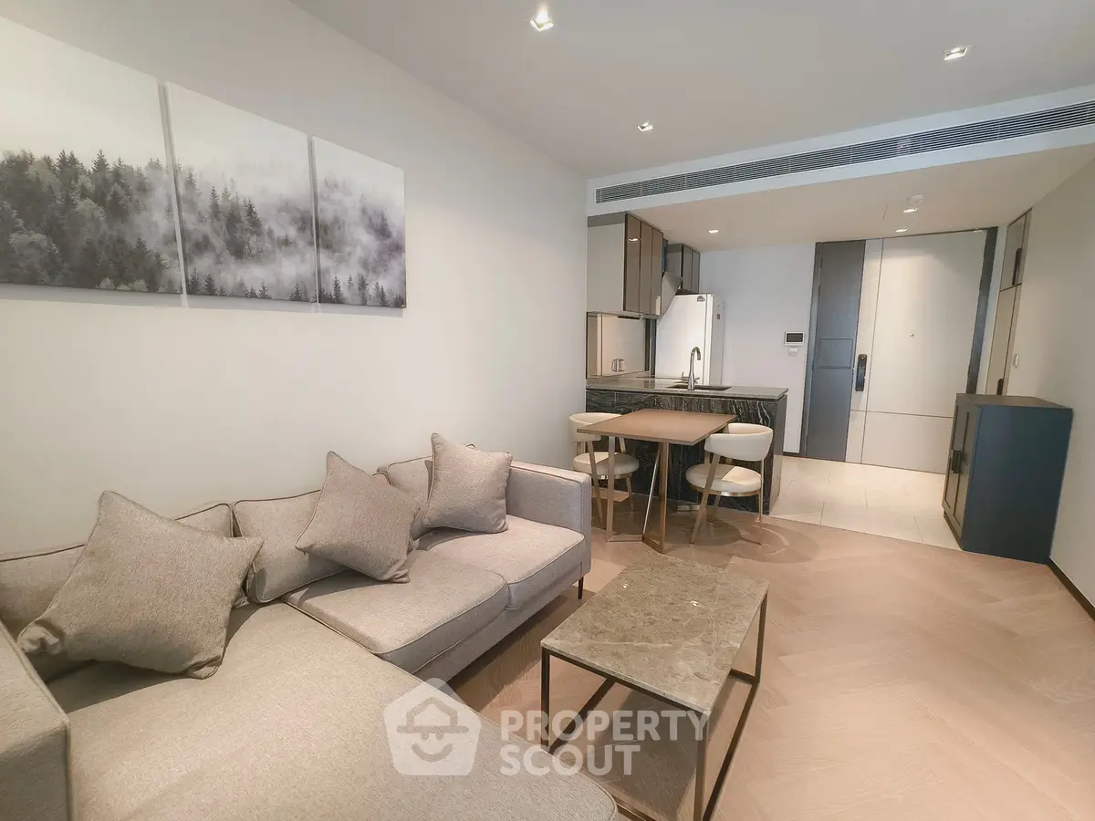Modern living room with open kitchen, stylish decor, and cozy seating area in a contemporary apartment.