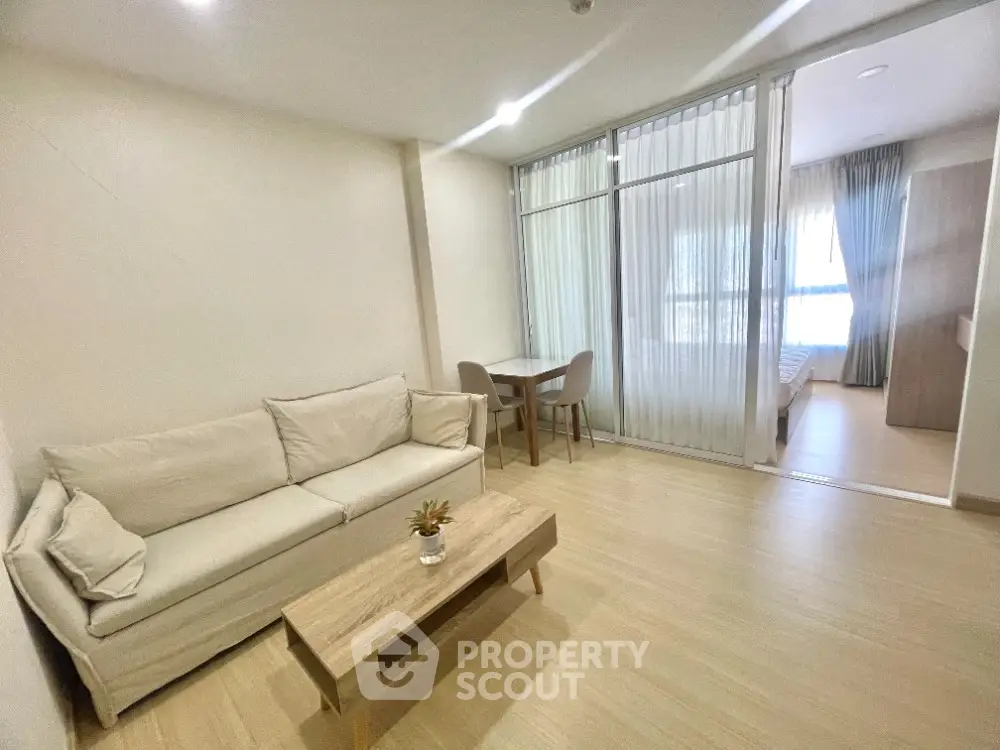 Modern living room with beige sofa and wooden coffee table in open layout apartment