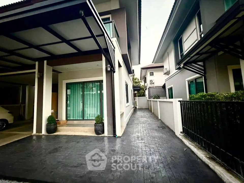Modern two-story house with driveway and carport in suburban neighborhood.