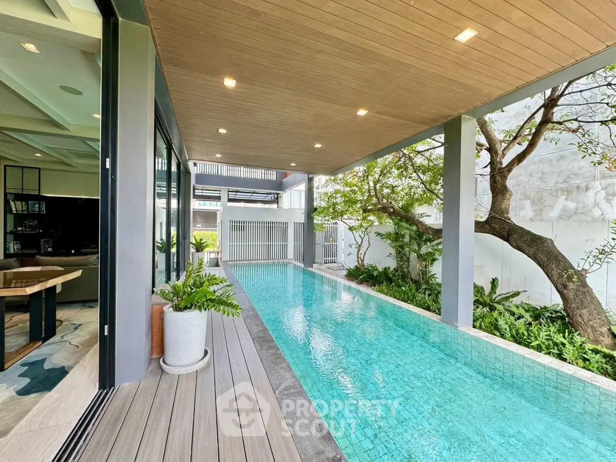 Luxurious modern home with stunning private pool and lush greenery, perfect for relaxation and entertainment.