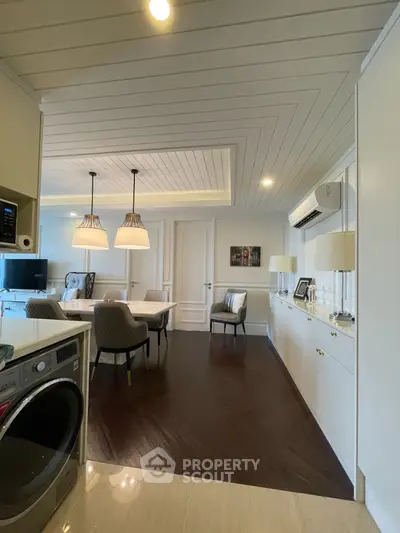 Elegant open-plan living and dining area with modern decor and stylish lighting