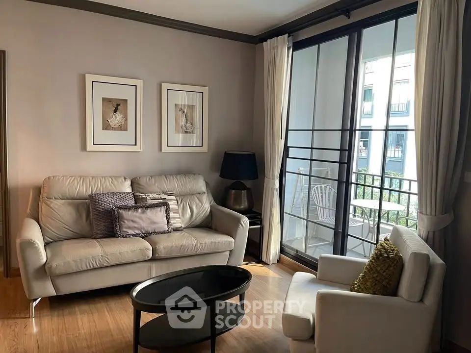 Charming living room with cozy seating and balcony access in modern apartment.