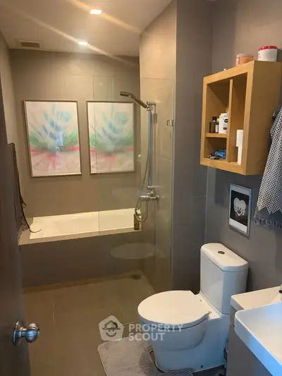 Modern bathroom with glass shower, bathtub, and stylish decor in a contemporary home.