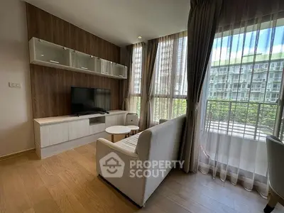 Modern living room with large windows and stylish furniture, offering a bright and inviting atmosphere.