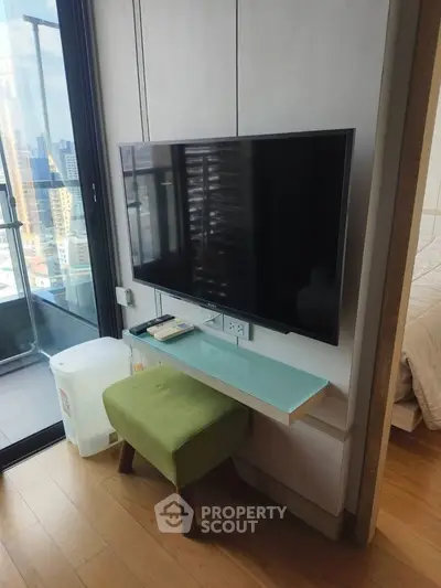Modern apartment interior with wall-mounted TV and balcony view