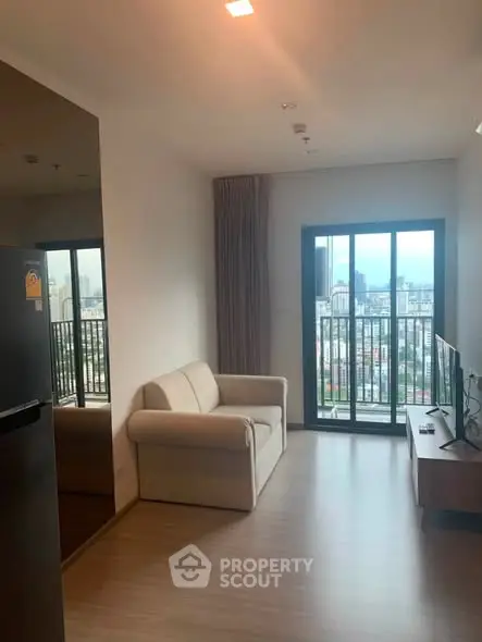 Modern living room with city view, featuring a cozy sofa and large window balcony.