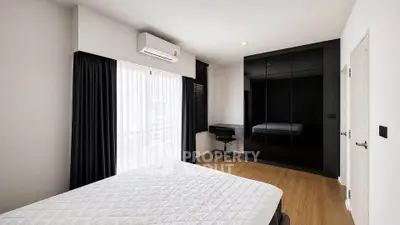 Modern bedroom with sleek black wardrobe and natural light