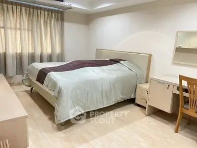 Spacious bedroom with elegant decor and natural light
