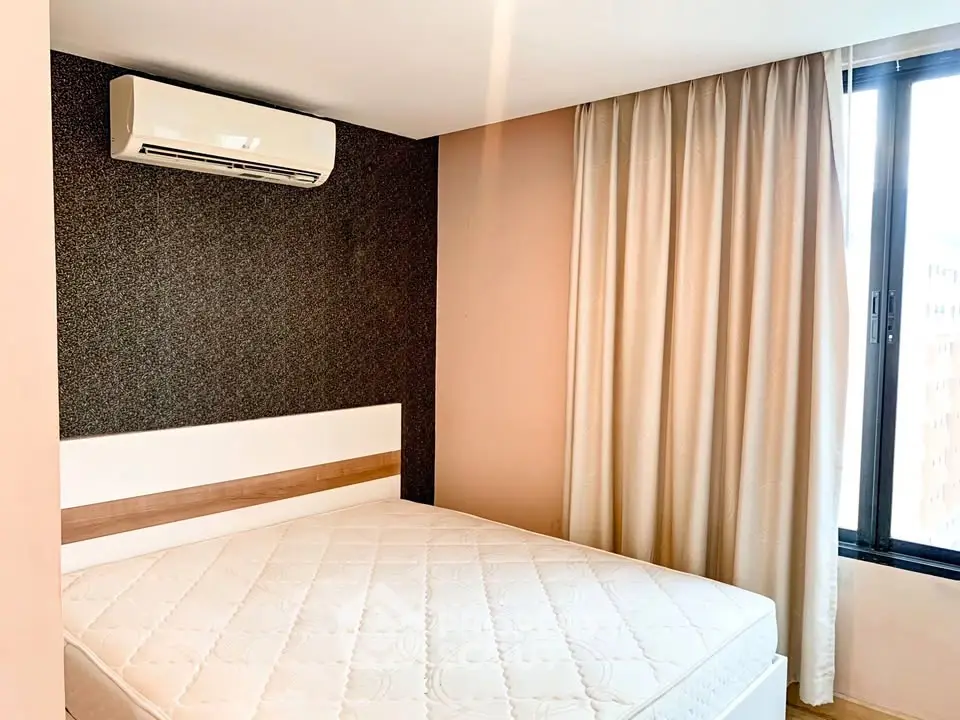 Modern bedroom with air conditioning and large window for natural light.