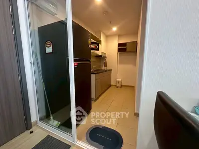 Modern kitchen with sleek cabinetry and spacious fridge in a cozy apartment setting.