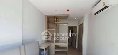 Modern bedroom with built-in wardrobe and air conditioning in a minimalist design.