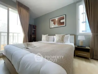 Elegant bedroom with modern decor, large window, and cozy bedding in a stylish apartment.