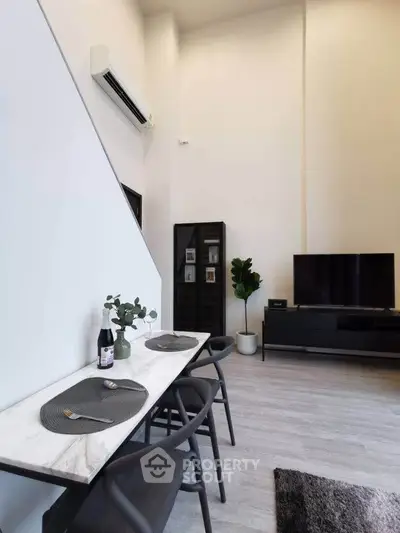 Modern living room with high ceiling, sleek furniture, and stylish decor