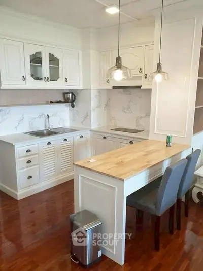 Charming kitchen with white cabinetry and wooden countertop, perfect for modern living.