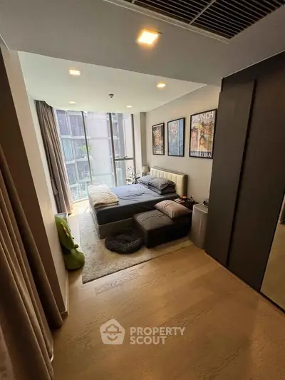 Modern bedroom with large windows and stylish decor in a high-rise apartment.