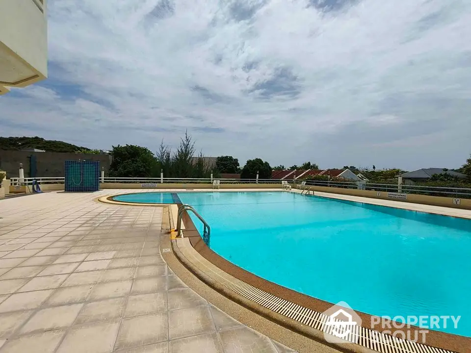 Stunning outdoor pool with clear blue water and spacious deck area, perfect for relaxation and leisure.