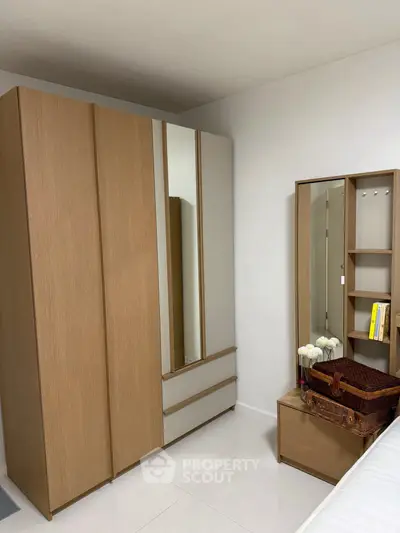 Modern bedroom with sleek wardrobe and stylish vanity in a contemporary apartment.