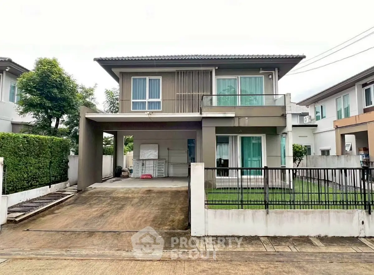 Modern two-story house with driveway and lush greenery in a serene neighborhood.