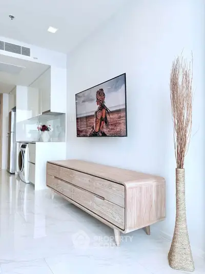 Modern living room with sleek wooden furniture and wall-mounted TV in stylish apartment.