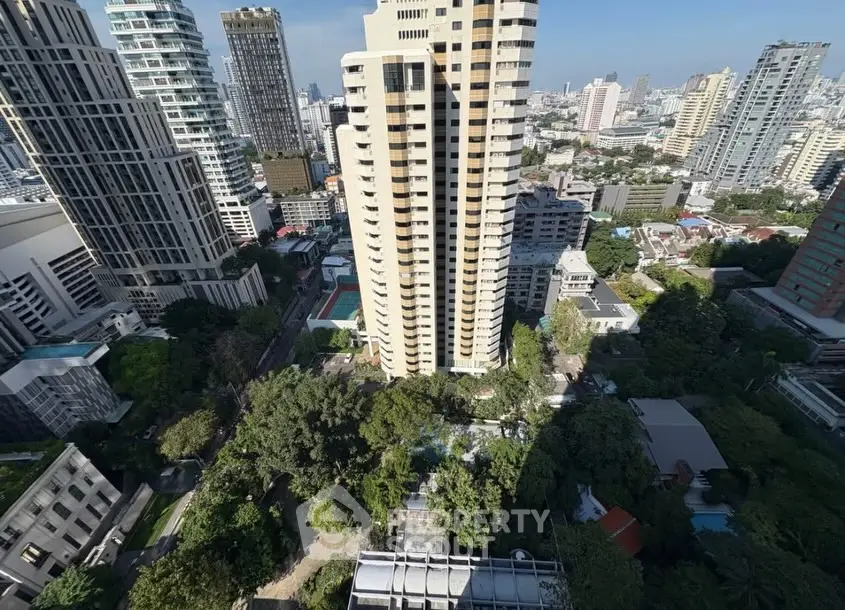 Stunning aerial view of urban high-rise buildings with lush greenery and cityscape.