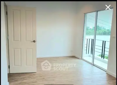 Bright empty room with wooden floor and balcony view